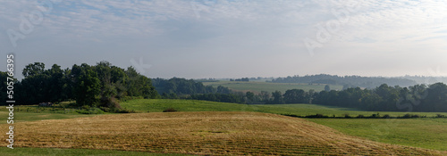 Amish farm fields and trees under a hazy sky in Holmes County, Ohio