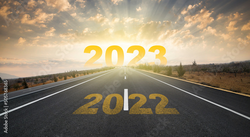 2023 anniversary. Transition from 2022 to the new year. Golden sunrise on asphalt empty road. New year concept with the number 2023 on the horizon. photo