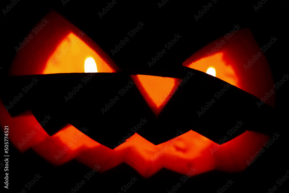 Scary pumpkin face with candles glowing in the night Scary pumpkin face with candles glowing in the night