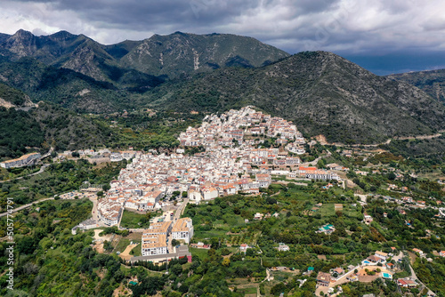 Aerial perspective of Ojen village, small white Andalusian town located in the mountains, in the heart of the Costa del Sol, not far from Marbella. In background beautiful mountains of Sierra Blanca 