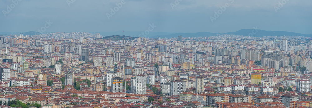 Panoramic aerial view of densely built-up district in Istanbul city with small mountains in the background