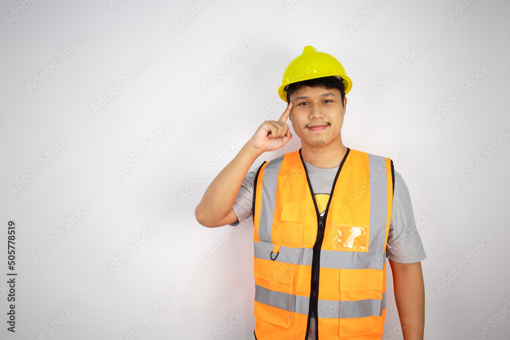 An Asian male engineer in a working uniform is smiling and looking at the camera with determination isolated on white background.