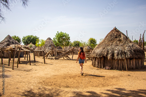 Woman walking between houses of the Karo tribe in southern Ethiopia, Omo Valley photo