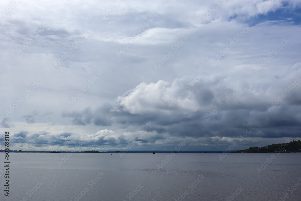 beautiful water landscape. a bunch of gray blue clouds. ships in the distance