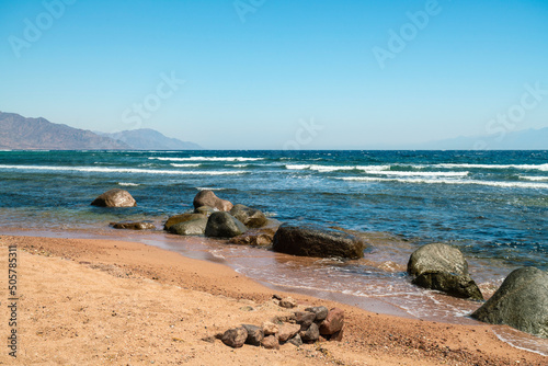Egypt, Sinai, Wet stones on beach and sea