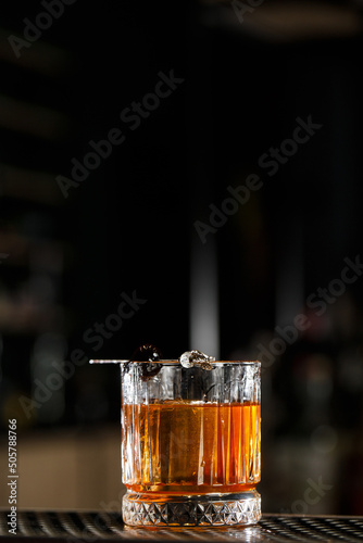 Obraz na płótnie Old fashioned cocktail, consisting of Bourbon, Angostura Bitter, sugar cubes, a few drops of water, ice cubes, orange, maraschino cherry w salonie