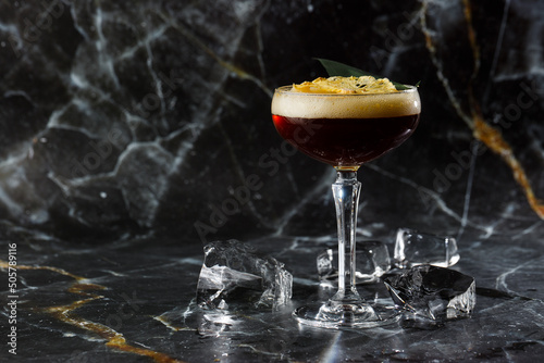 White russian cocktail, trendy alcoholic drink with vodka, coffee liqueur, cream and ice on black marble background
