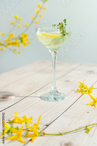 Glass of bees knees summer gin cocktail with lemon and thyme.