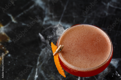 Obraz na płótnie A red sour cocktail in a coupe glass garnished with an orange peel. Clover club with imported gin. w salonie