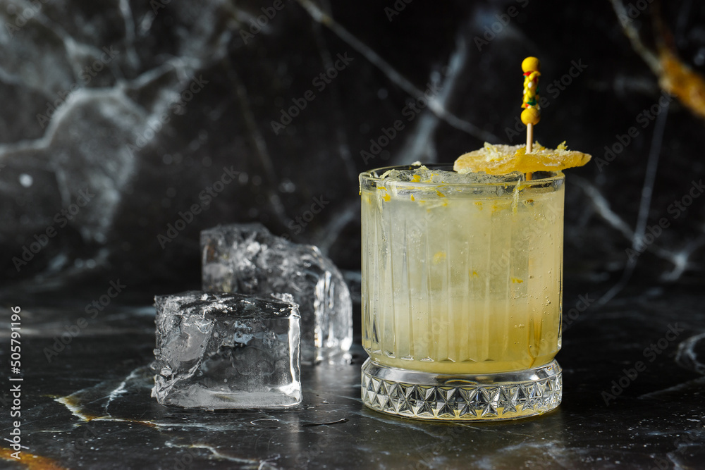 Alcoholic Scotch Whiskey Penicillin Drink Cocktail with Lemon, Honey syrup and Candied Ginger. Cocktail glass on black background