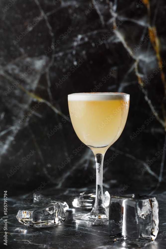 Pisco sour cocktail - whiskey with lime, egg white, sugar syrup in glass on dark blurred background. Space for text