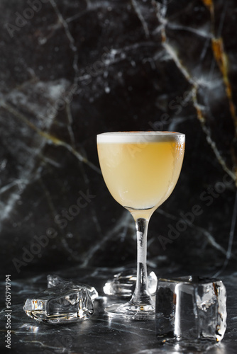 Obraz na płótnie Pisco sour cocktail - whiskey with lime, egg white, sugar syrup in glass on dark blurred background. Space for text w salonie