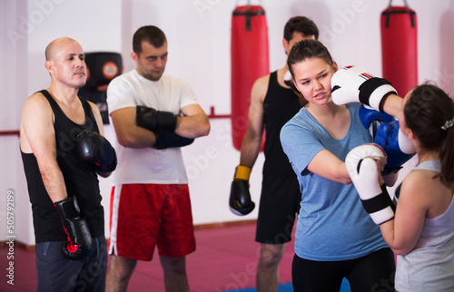 Two young athlete women practicing boxing sparring in gym
