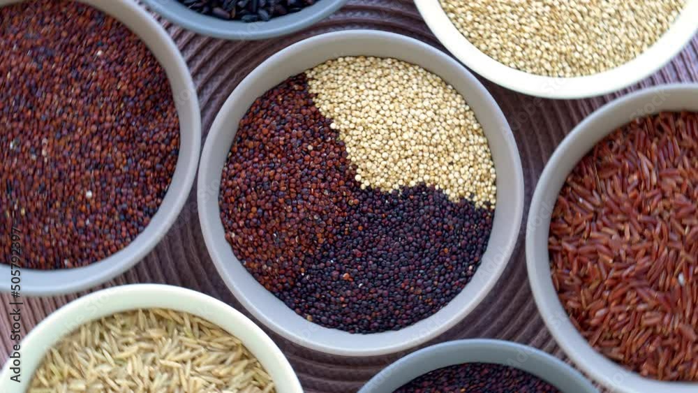 Set of colorful collection of rice and quinoa grains of different colors: white, red and black in bowls. Top view, table spin, zoom-in. Set of colorful collection of rice and quinoa grains of different colors: white, red and black in bowls. Top view, table spin, zoom-in.