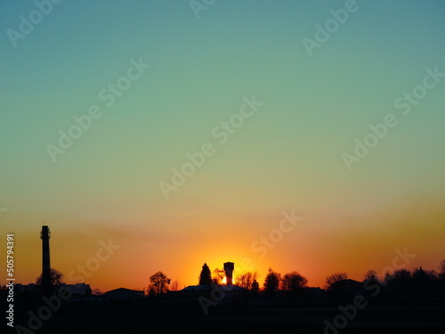 Sunset sky with water tower and chimney landscape