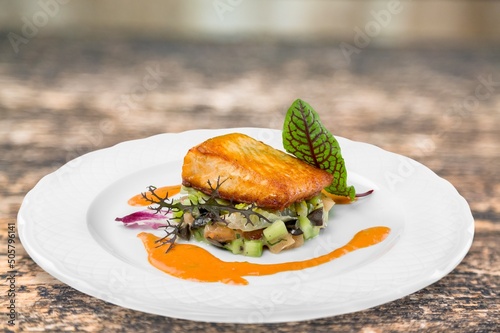 Fried meat or fish with vegetable and salad on kitchen desk photo