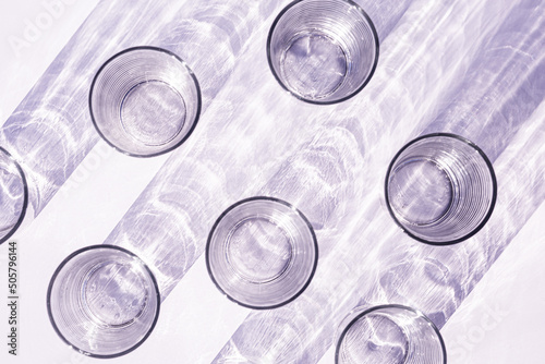 Purple glasses reflecting light throwing rippled shadow pattern