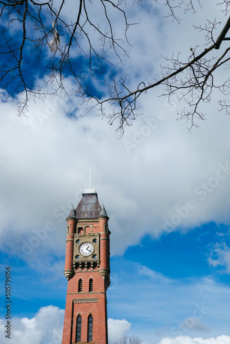 Clock tower against a winter sky with deciduous tree branches photo