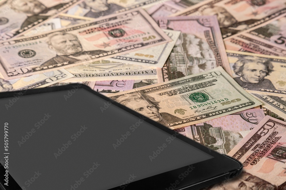 Digital table on stack of dollar currency Digital table on stack of dollar currency
