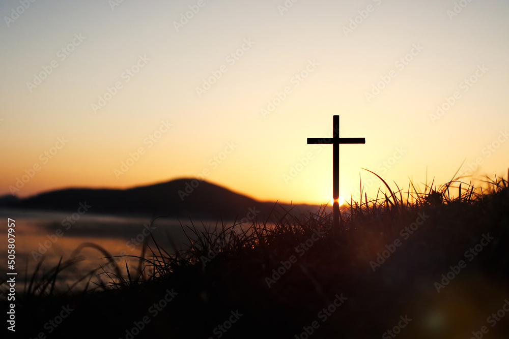 노을 하늘 강한 빛과 풀밭위에예수 그리스도의 거룩한 십자가는 죽음과 부활 사랑을 상징합니다.

