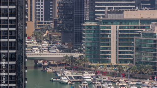 Many yachts and boats are parked in harbor aerial timelapse in Dubai Marina