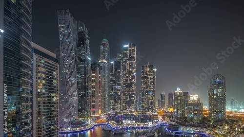 Dubai marina tallest skyscrapers and yachts in harbor aerial night timelapse. #505815147
