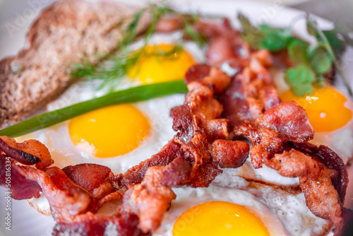 Tasty fried eggs eggs and crispy bacon, close-up, great classic breakfast. Macro photography, shallow depth of field.