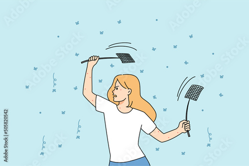Woman with fly swatters killing mosquitos 