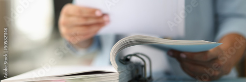 Business woman in suit looking documents from folder closeup photo