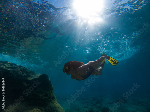 beautiful woman swimming underwater with snorkeling mask and flippers