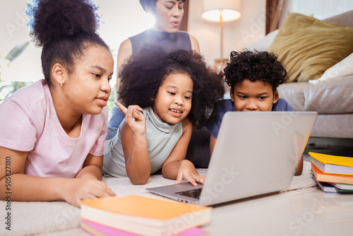 Happy African American family studying online by computer laptop at home photo