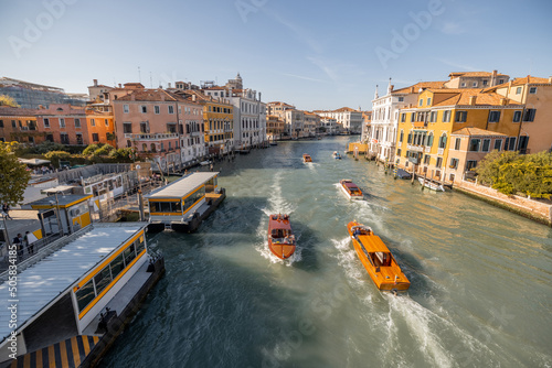 View on Grand Canal with vaporetto and gondolas in Venice. Venetian water transportation concept. Idea of traveling Italy. Cityscape in autumn sunny day photo