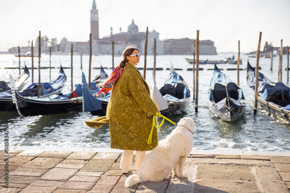 Φωτογραφία Young woman walking with dog near water canal with gondolas at saint Marks square in Venice