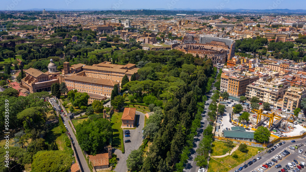 Aerial view of Colosseum and the Arch of Titus, in Italy, on a sunny day. These monuments of ancient Rome are a symbol of the city and visited by many tourists every day.