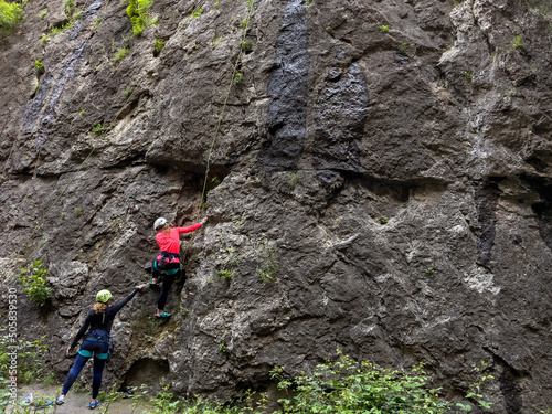 Climber people climbing a natural rocky wall. Extreme sports, healthy lifestyle and adventure concept.