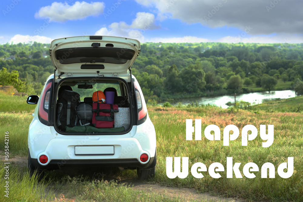 Happy Weekend. Car with camping equipment in green field