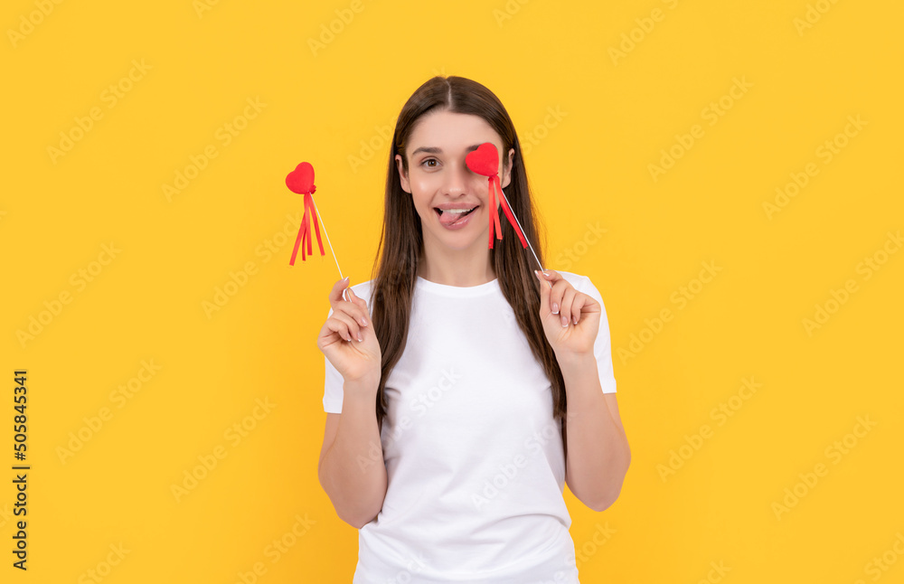 positive girl hold heart in white shirt on yellow background, 14 february