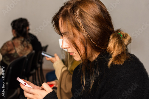 Young woman in a conference using her mobile phone