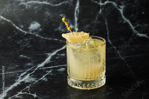 Obraz na płótnie Alcoholic Scotch Whiskey Penicillin Drink Cocktail with Lemon, Honey syrup and Candied Ginger. Cocktail glass on black background w salonie