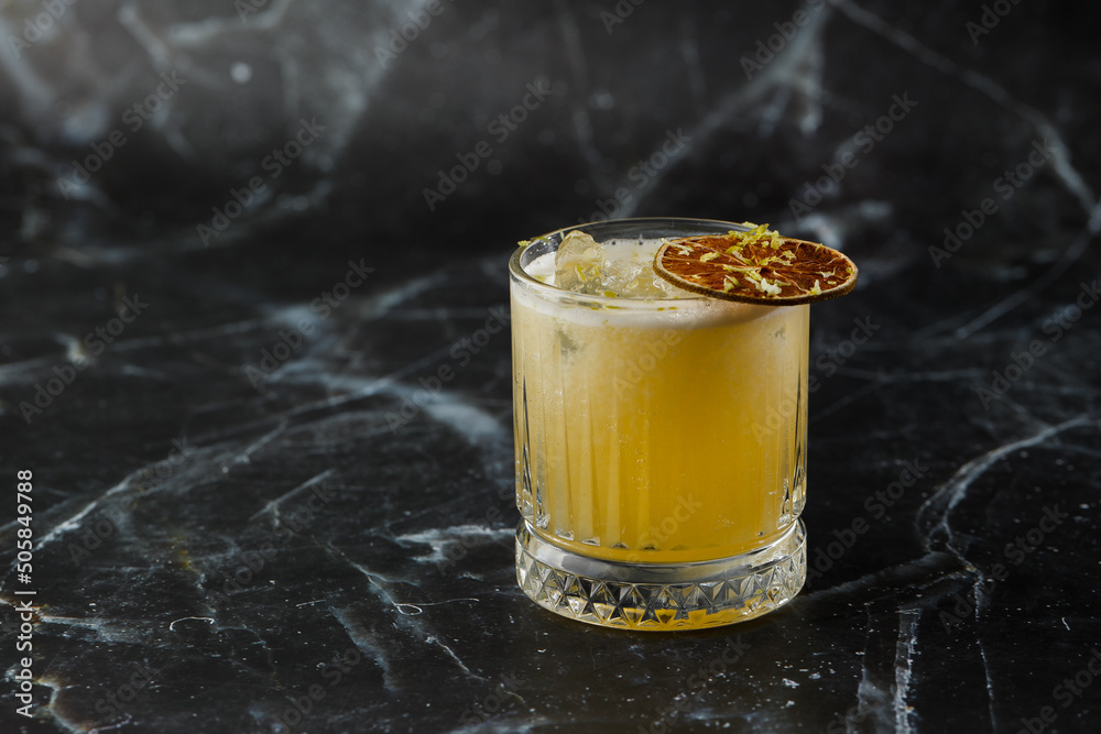 Fruit mixology with mezcal and dry lime on black marble background. Warm colored cocktails. Mezcal cocktail.