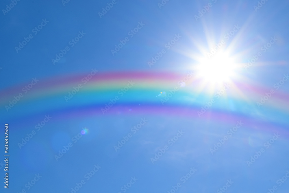 Beautiful view of bright rainbow in blue sky on sunny day