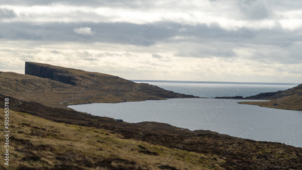 Beautiful aerial view of the Bøsdalafossur waterfall and Trælanípan magnificent landmarks in the Faroe Islands