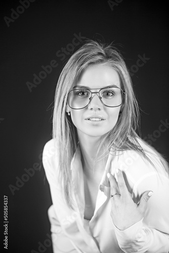 Portrait of a smiling businesswoman standing with amazing sexy look over black background.