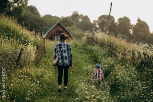 Summer trip with children to the mountains. Evening walk of a mother with a child in an alpine village in summer. © sergo321
