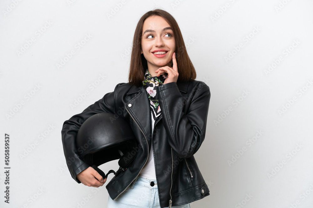 Young Ukrainian woman with a motorcycle helmet isolated on white background thinking an idea while looking up Young Ukrainian woman with a motorcycle helmet isolated on white background thinking an idea while looking up