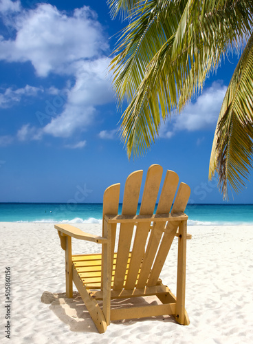 Yellow lounge chair on white sand beach