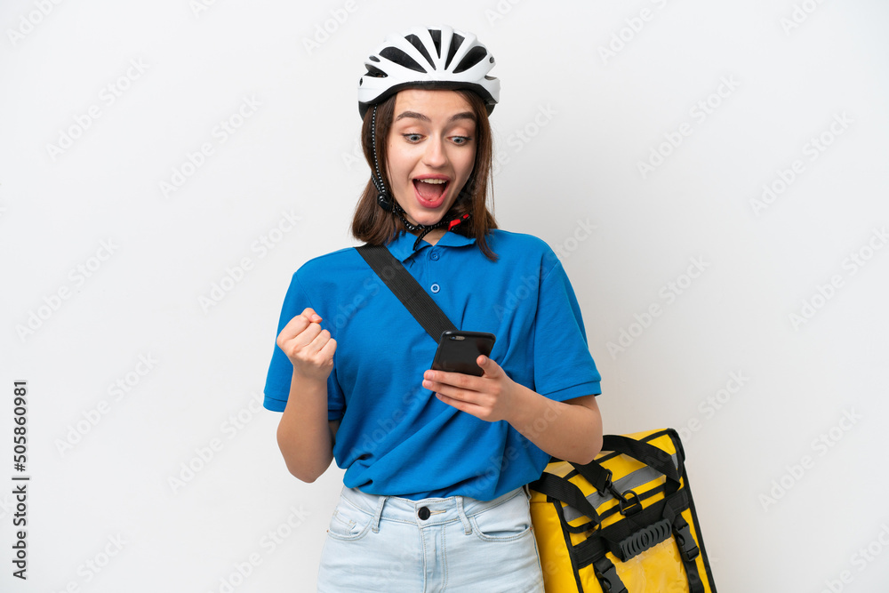 Young Ukrainian woman with thermal backpack isolated on white background surprised and sending a message Young Ukrainian woman with thermal backpack isolated on white background surprised and sending a message