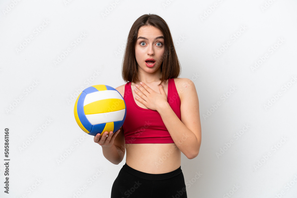 Young Ukrainian woman playing volleyball isolated on white background surprised and shocked while looking right