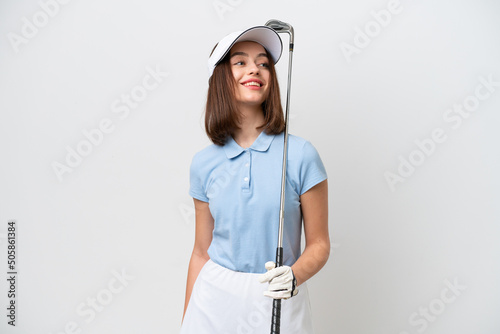 Young Ukrainian woman isolated on white background playing golf photo