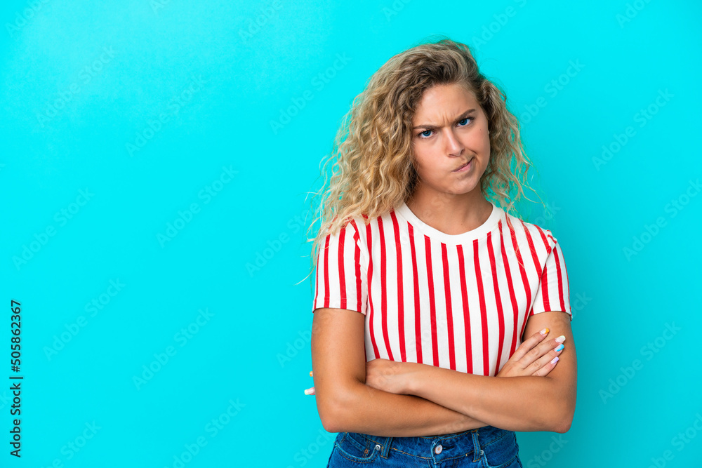 Girl with curly hair isolated on blue background feeling upset Girl with curly hair isolated on blue background feeling upset